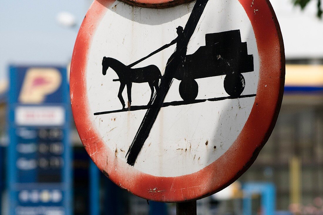 Road sign in Babadag, forbidden for horse carts and modern petrol station, old and new times, Romania