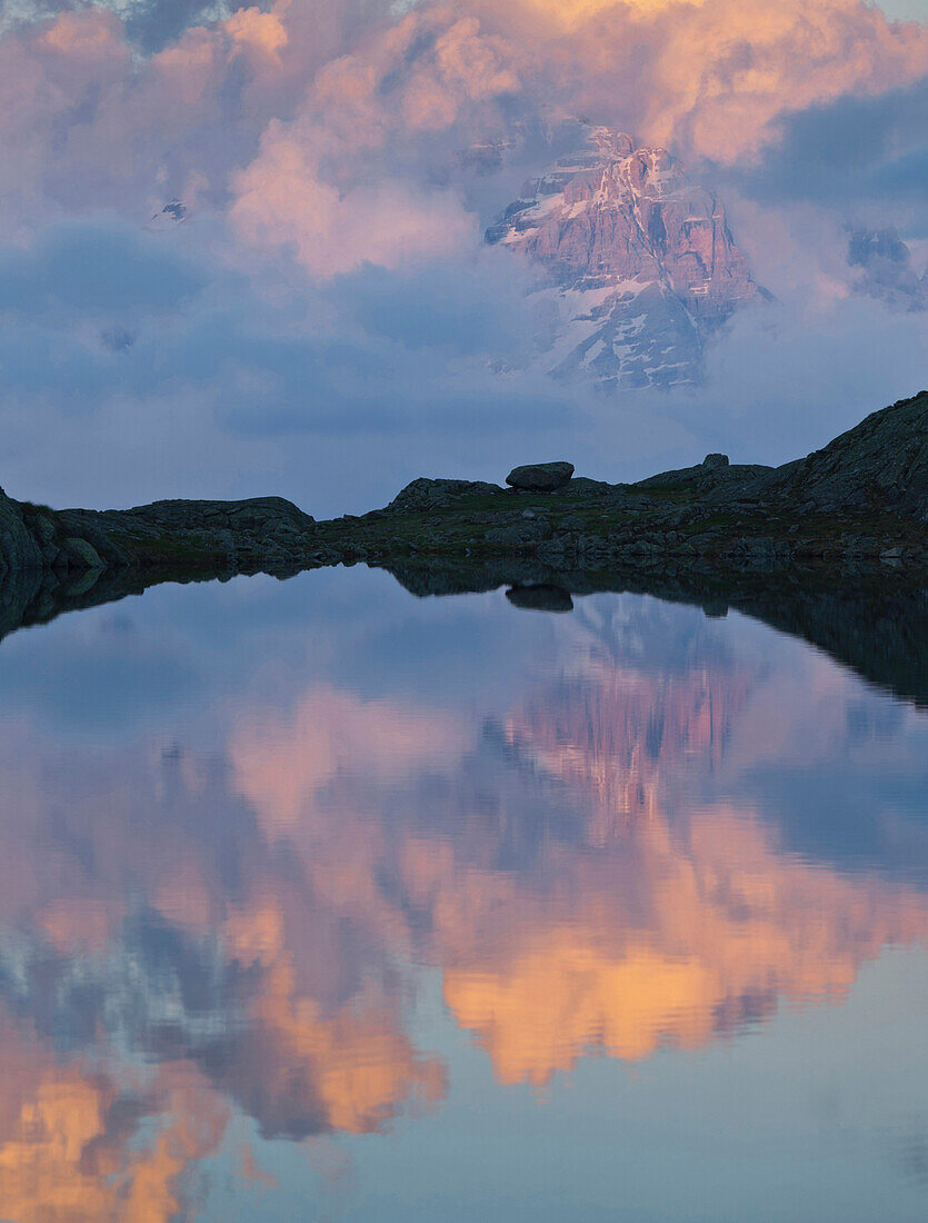 Reflection of the Brenta Massiv mountain range in a mountain lake, Lago Nero, Brenta Adamello Nature Reserve, Trentino, Italy