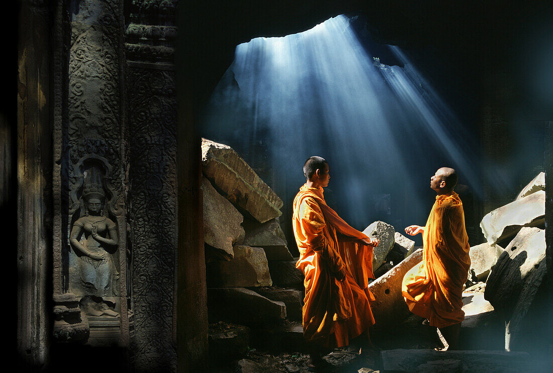 Mönche unter einem zerstörten Dach von Ta Prohm Tempel, Angkor, Kambodscha, Asien