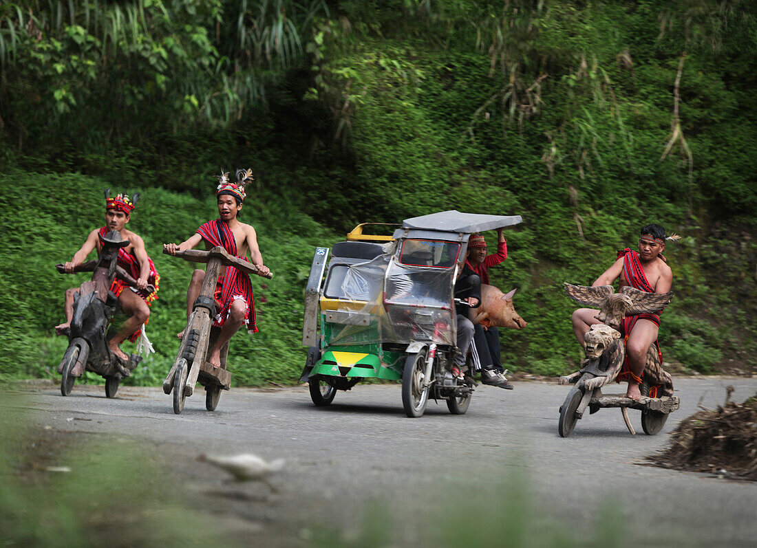 Ifugao men speeding on wooden scooters, Banaue, Ifugao, Luzon Island, Philippines
