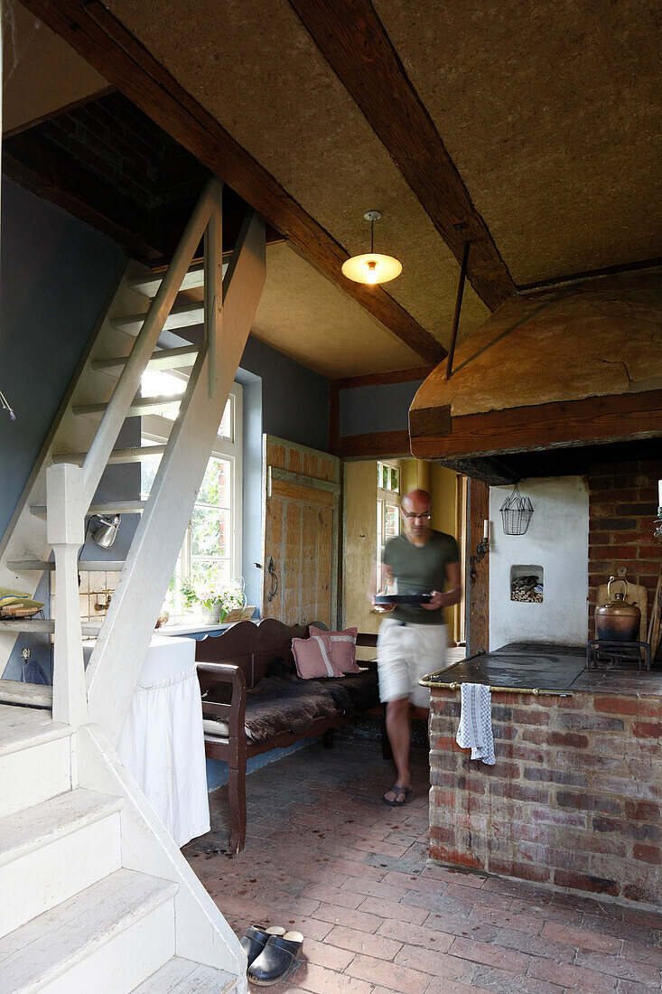 Man carrying a baking pan in a kitchen, Klein Thurow, Roggendorf, Mecklenburg-Western Pomerania, Germany