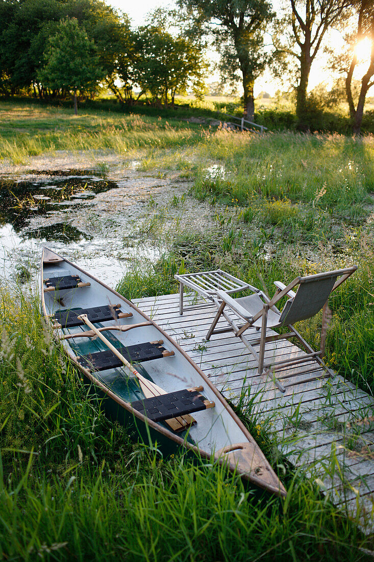 Pond with jetty and canoe, Klein Thurow, Roggendorf, Mecklenburg-Western Pomerania, Germany