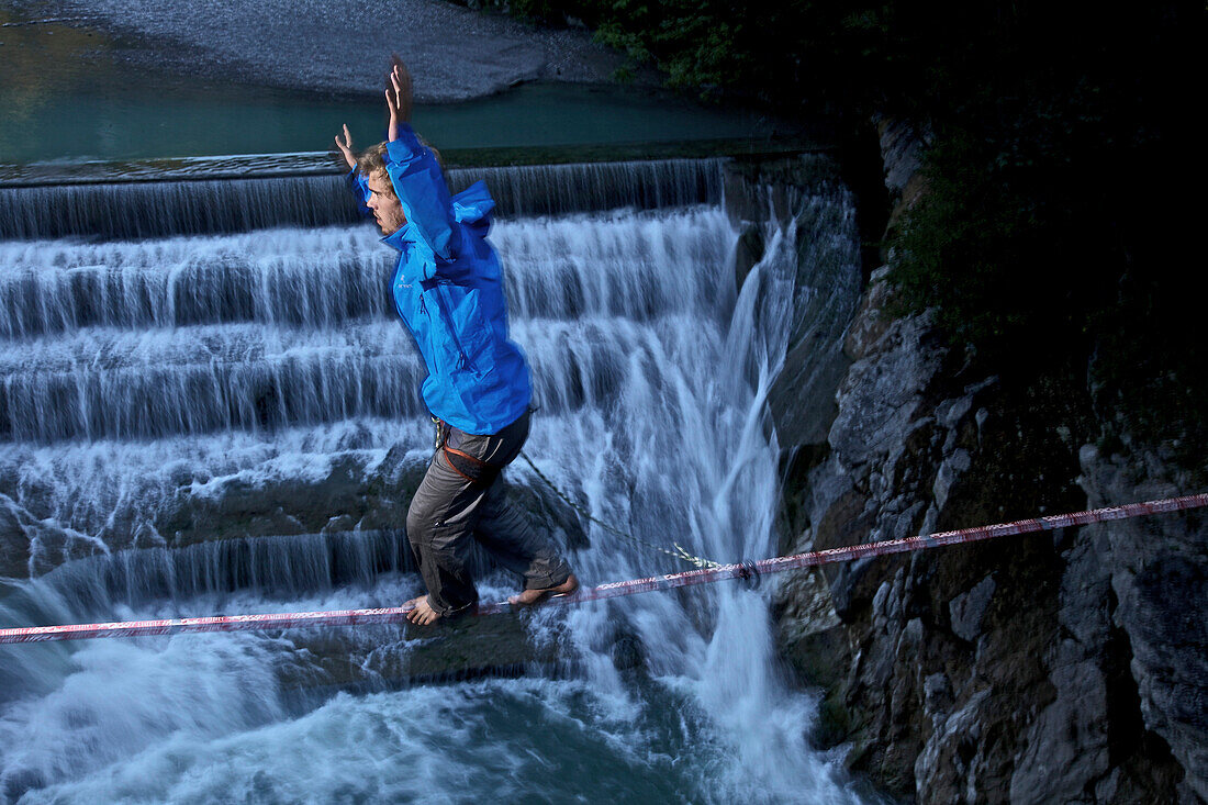 Junger Mann balanciert auf einer Highline über einen Fluss, Füssen, Bayern, Deutschland, Europa