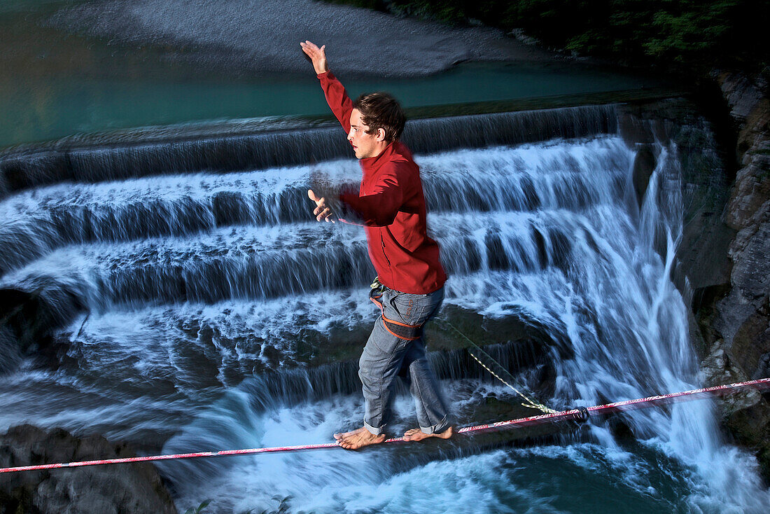 Junger Mann balanciert auf einer Highline über einen Fluss, Füssen, Bayern, Deutschland, Europa