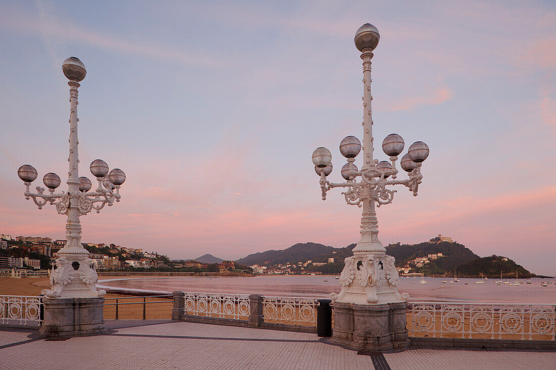 Laternen auf der Uferpromenade in der Abenddämmerung, Playa de la Concha, Bahia de la Concha, San Sebastian, Donostia, Camino de la costa, Jakobsweg, Camino de Santiago, Pilgerweg, Provinz Guipuzcoa, Baskenland, Euskadi, Nordspanien, Spanien, Europa