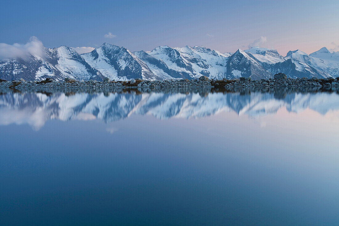 Reflection of mountains in the reservoir at Laemmerbichlalm, Zillertaler Alps, Tyrol, Austria