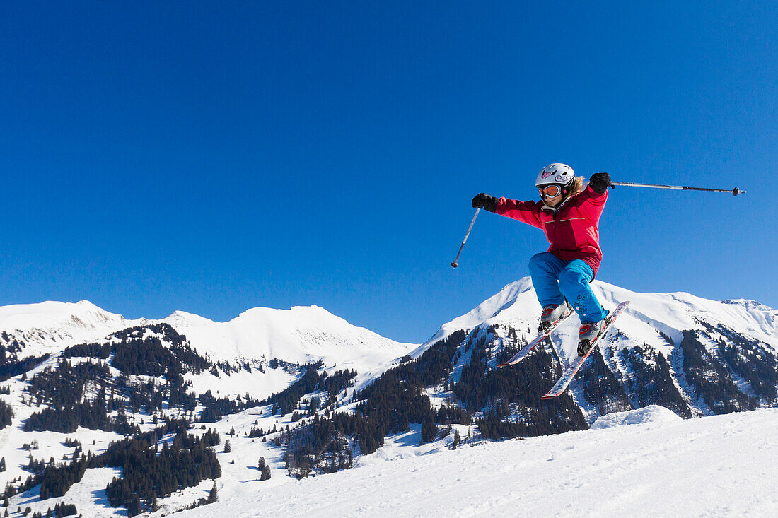A child, a girl on skis jumping, Skiresort Wiriehorn, Diemtigtal valley, Bernese Oberland, Switzerland, Europe