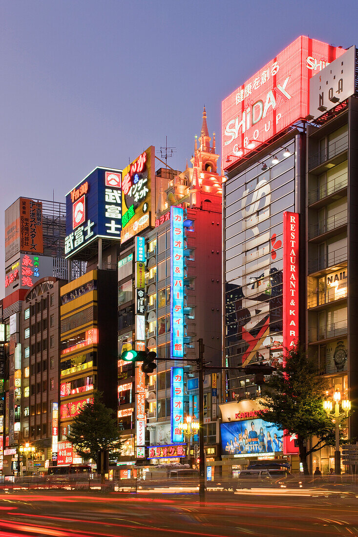 Neon blends with twilight and towering Karaoke Pubs in the popular Kabukicho area of the Shinjuku District in Tokyo, Japan.