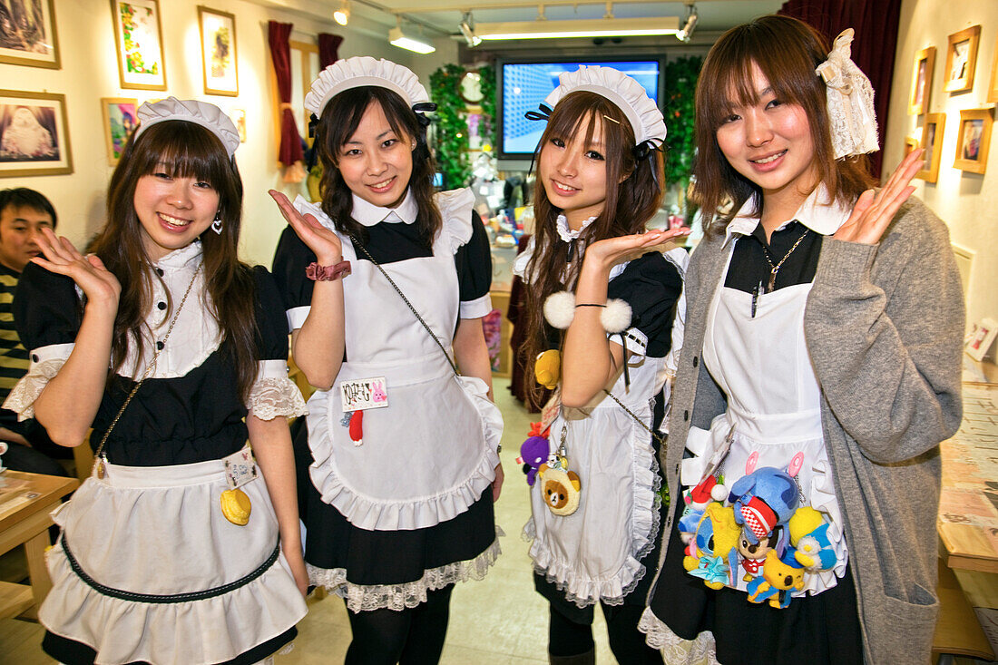 Cute young Japanese girls working at Popopure Maid Cafe wear French maid's uniforms and perpetual smiles in Akihabara located near the Kanda River in the Chiyoda-ku District, Tokyo, Japan