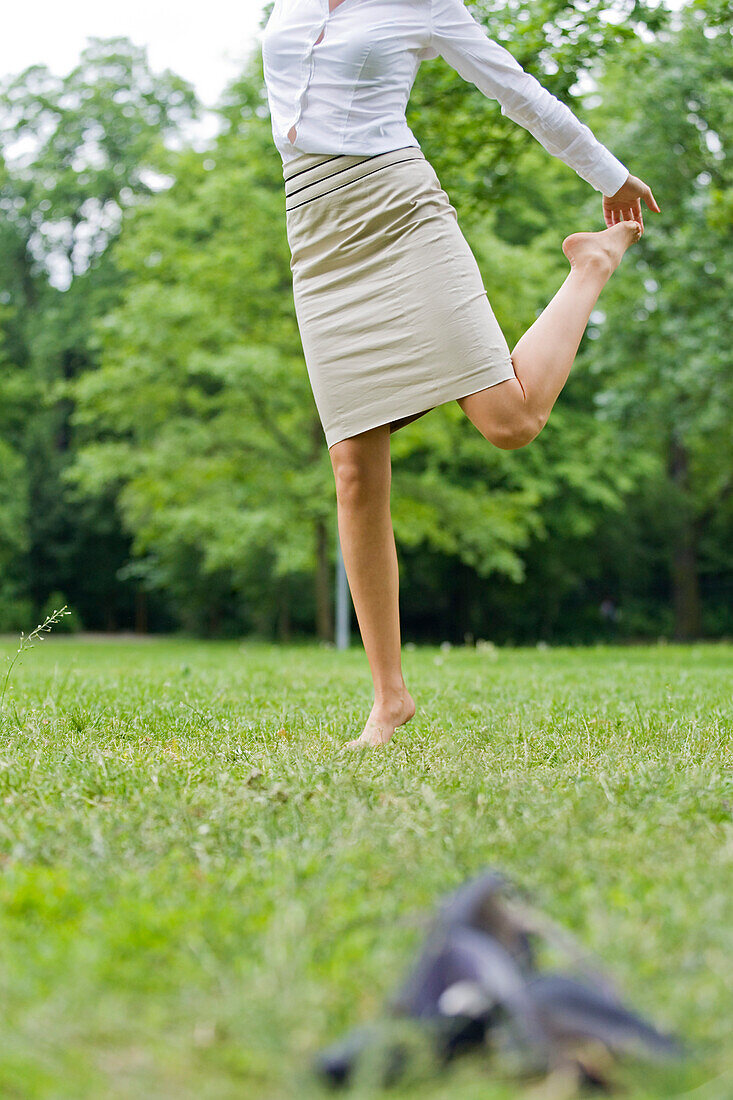 Body of a businesswoman content in park without shoes