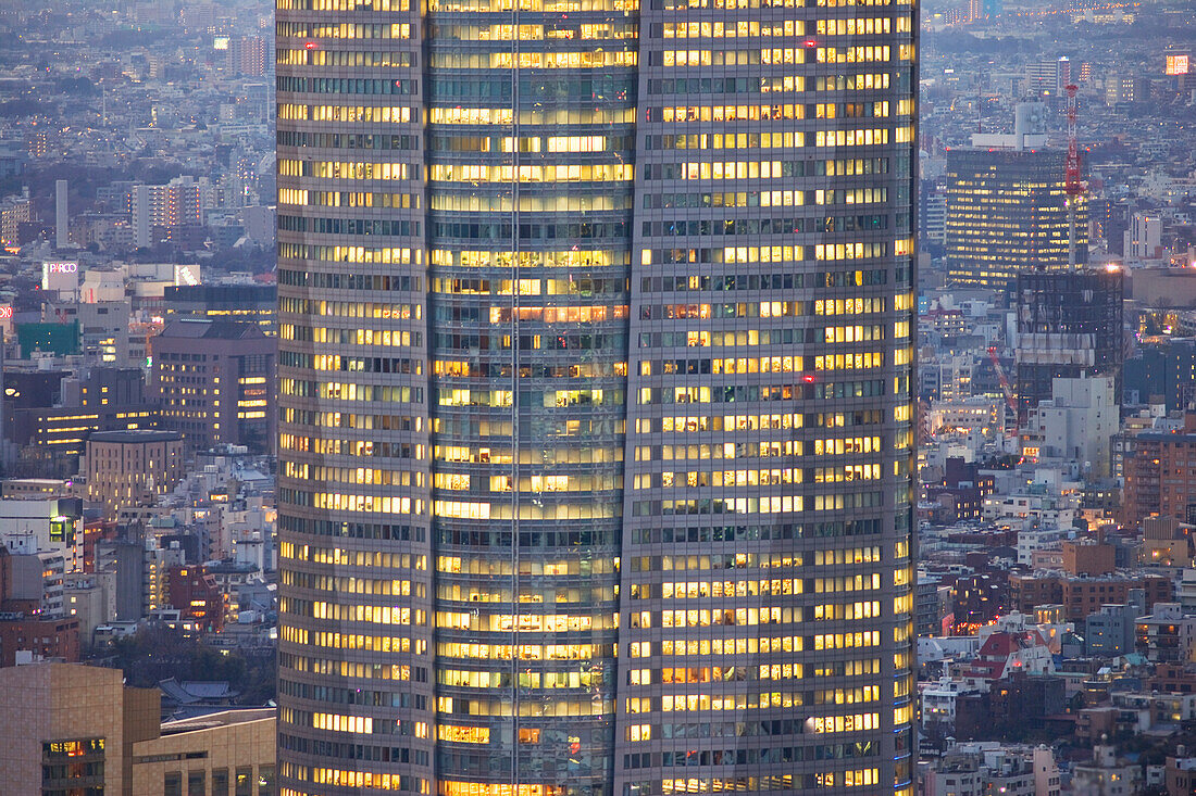 Mori Tower, in the Roppongi Hills business complex, rises high above the surrounding city in this telephoto view at twilight from Tokyo Tower Observatory in central Tokyo, Japan.