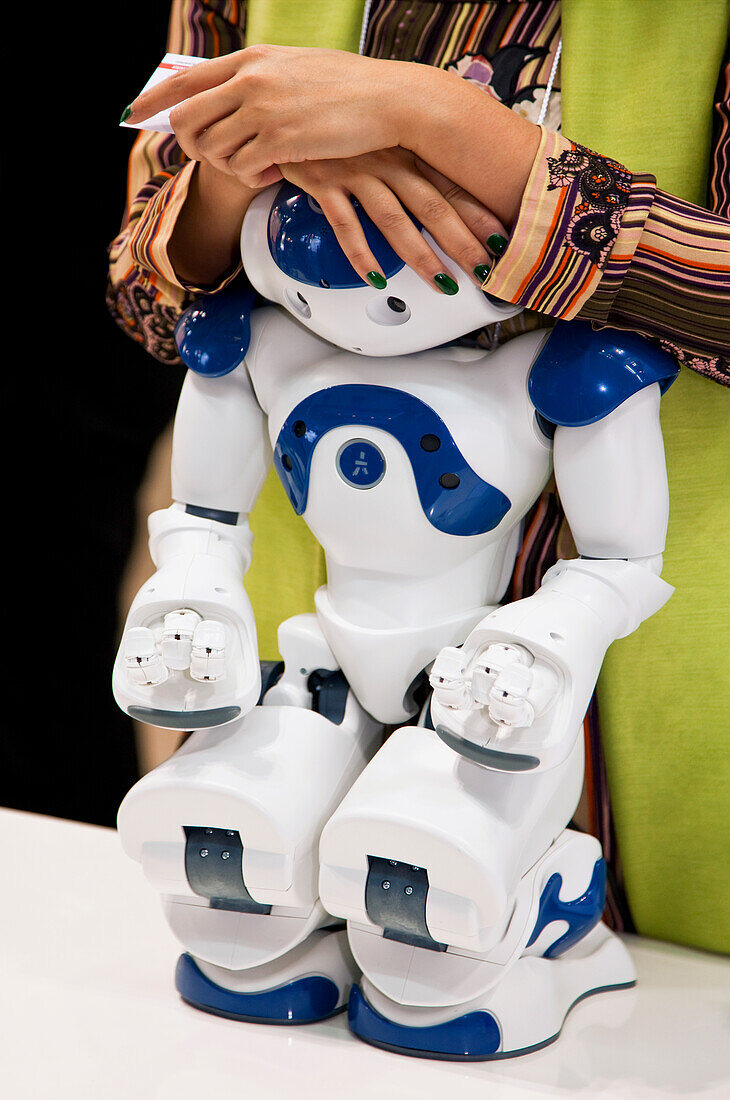 A staff member rests her hands on a demonstration service robot at the annual International Robot Exhibition, which attracts industry professionals as well as tech-geeks to Tokyo Big Sight, a modern convention center located in the Odaiba District o [...]