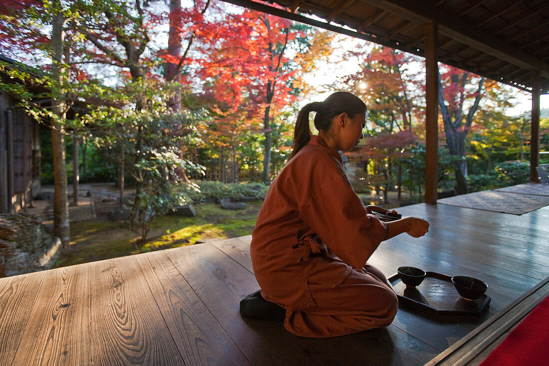 An attendant serves macha green tea to visitors viewing the garden at Daiho-in, a sub-temple inside Myoshinji Temple complex, located in Kyoto, Japan.