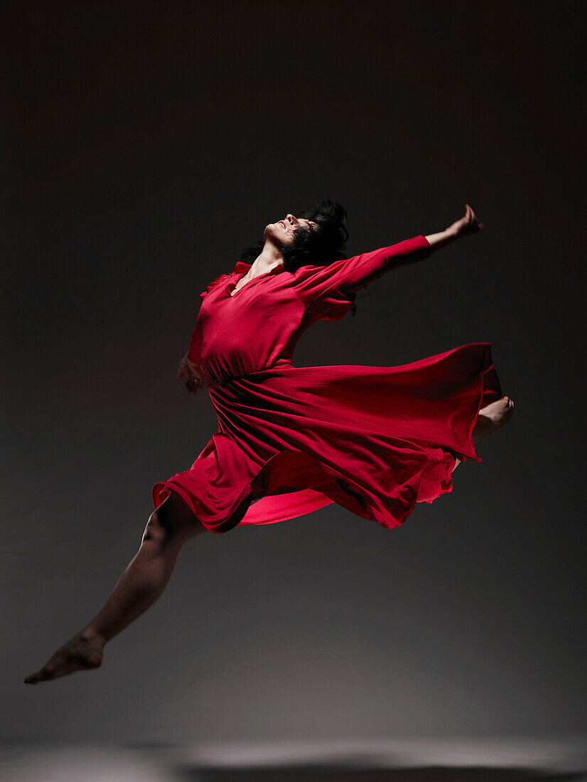 Woman in Red dress dancing under light