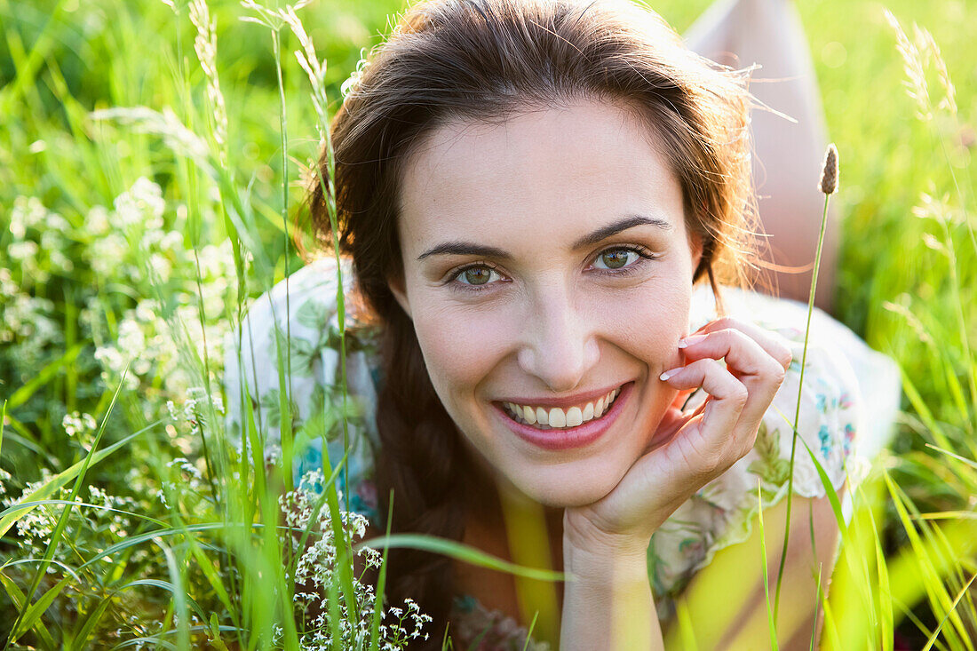 Smiling woman laying in tall grass