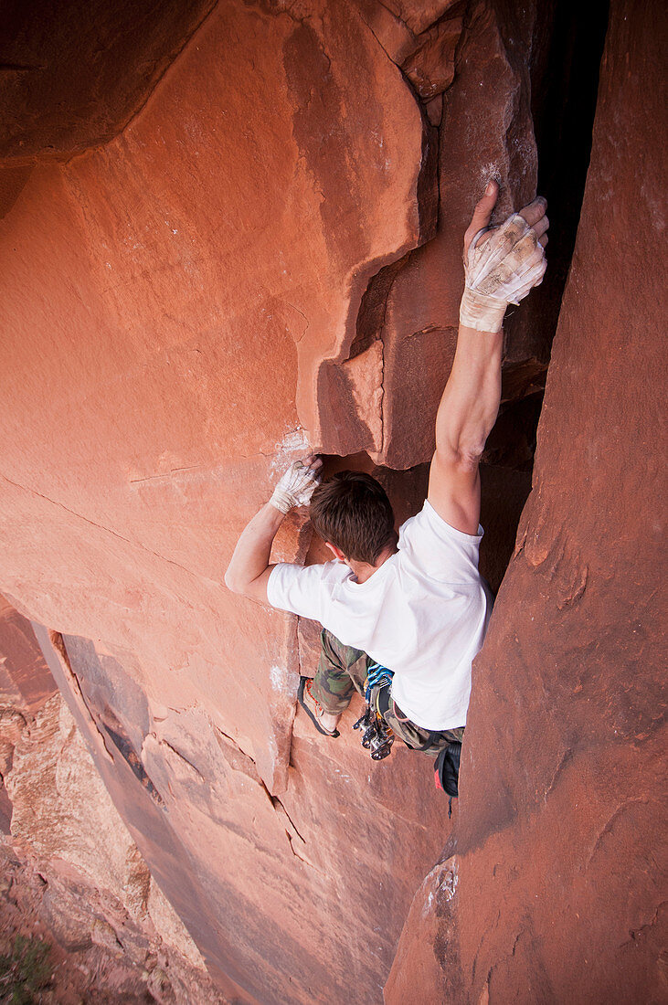 Rock climber scaling boulder crack