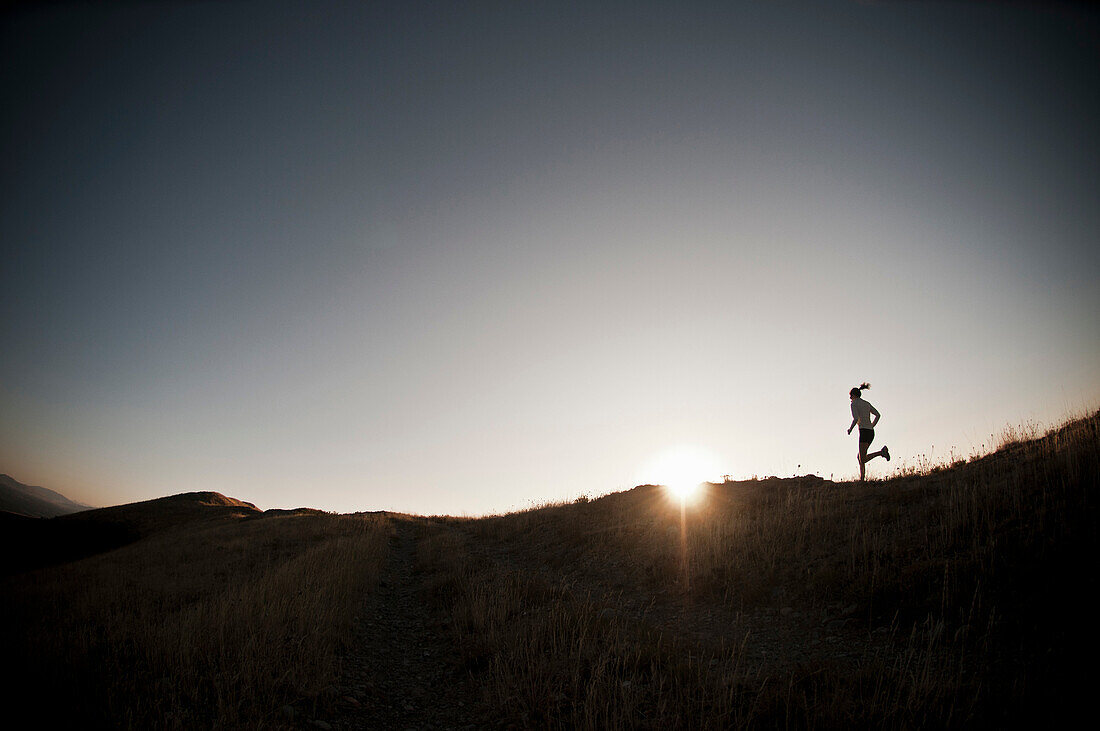 Woman running on dirt path. Bonneville Shoreline taril, Wasatch Foothills near Salt Lake City, Utah