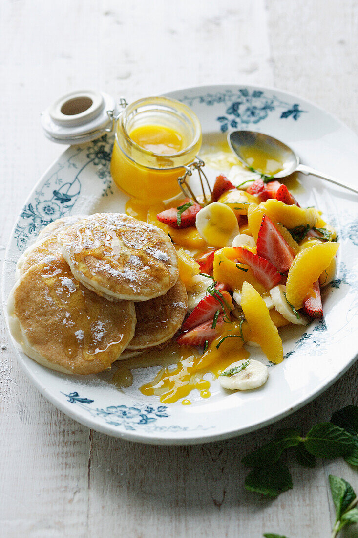 Plate of pancakes with fruit salad. PikeletsMangoSalad