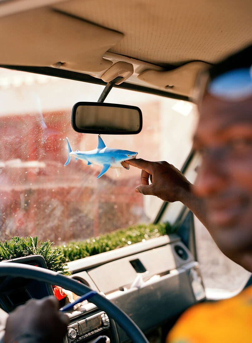 Fischer im Auto mit Plastikhai in seinem Auto am Fischmarkt, Mindelo, Insel Sao Vicente, Ilhas de Barlavento, Republic Kap Verde, Afrika