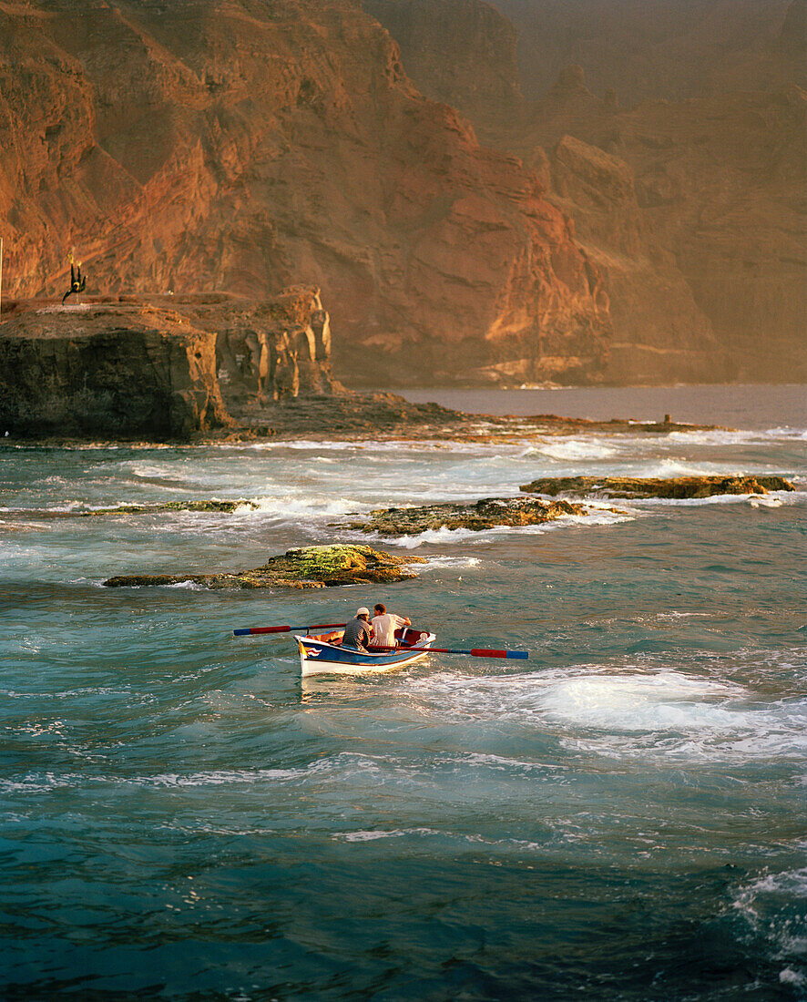 Fishing boat heading towards the natural harbour Boca de Pistol in the evening light, Ponta do Sol, Santo Antao, Ilhas de Barlavento, Republic of Cape Verde, Africa