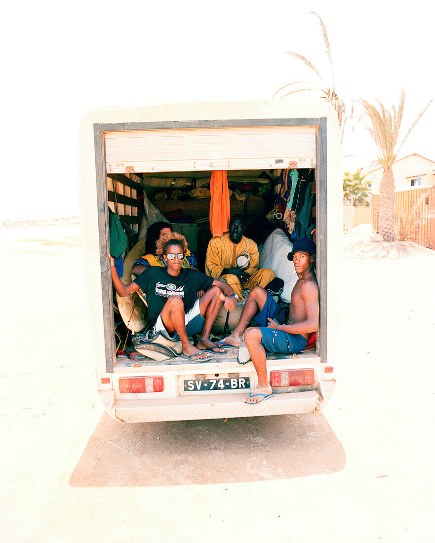 Delivery truck with surfers and african musicians driving to surf spot Ponta Preta, west of Santa Maria, Sal, Ilhas de Barlavento, Republic of Cape Verde, Africa