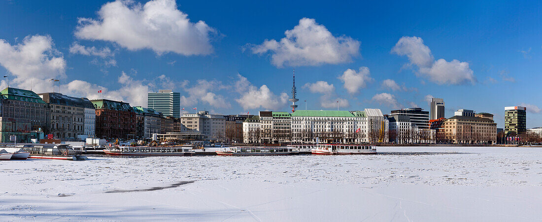 Panorama of the Binnen Alster covered in snow and ice and the buildings along the Neuer Jungfernstieg, Hamburg, Germany