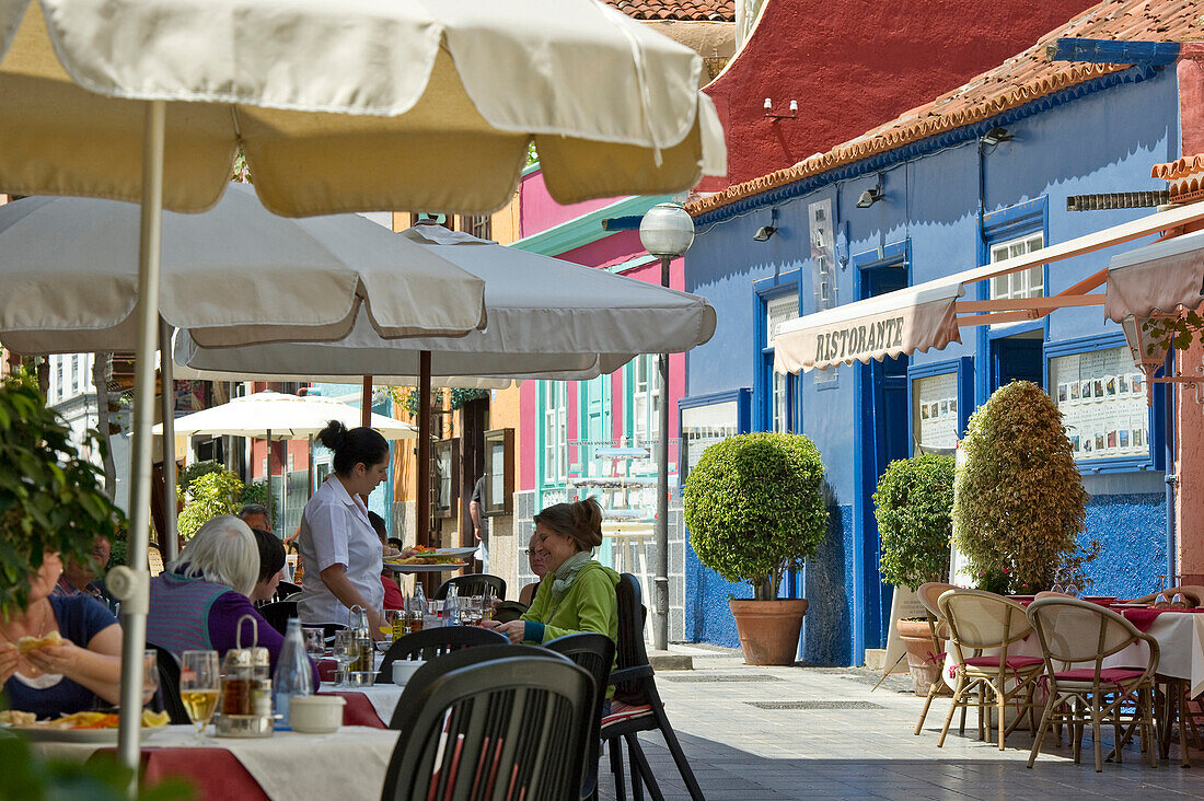 Menschen sitzen vor Restaurants, Puerto de la Cruz, Teneriffa, Kanarische Inseln, Spanien, Europa