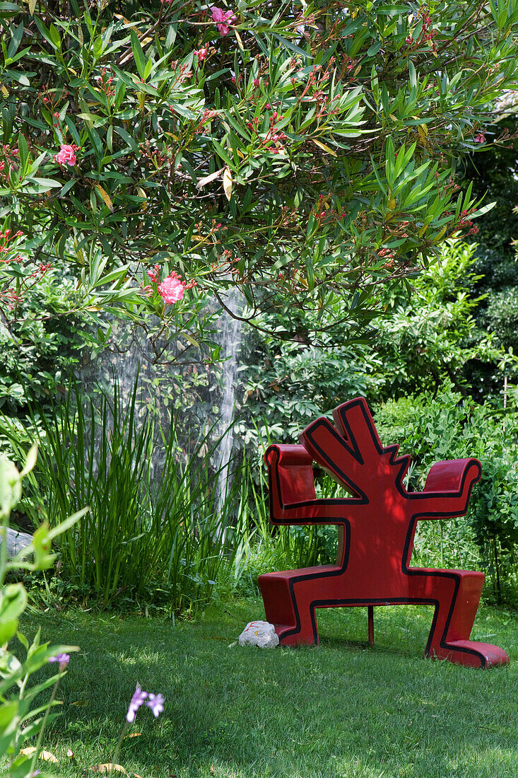 A Keith Haring sculpture with fountain in the background at Andre Hellers' Garden, Giardino Botanico, Gardone Riviera, Lake Garda, Lombardy, Italy, Europe