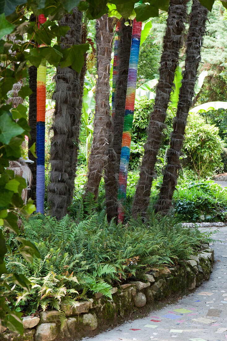 Painted tree trunks at Andre Hellers' Garden, Giardino Botanico, Gardone Riviera, Lake Garda, Lombardy, Italy, Europe