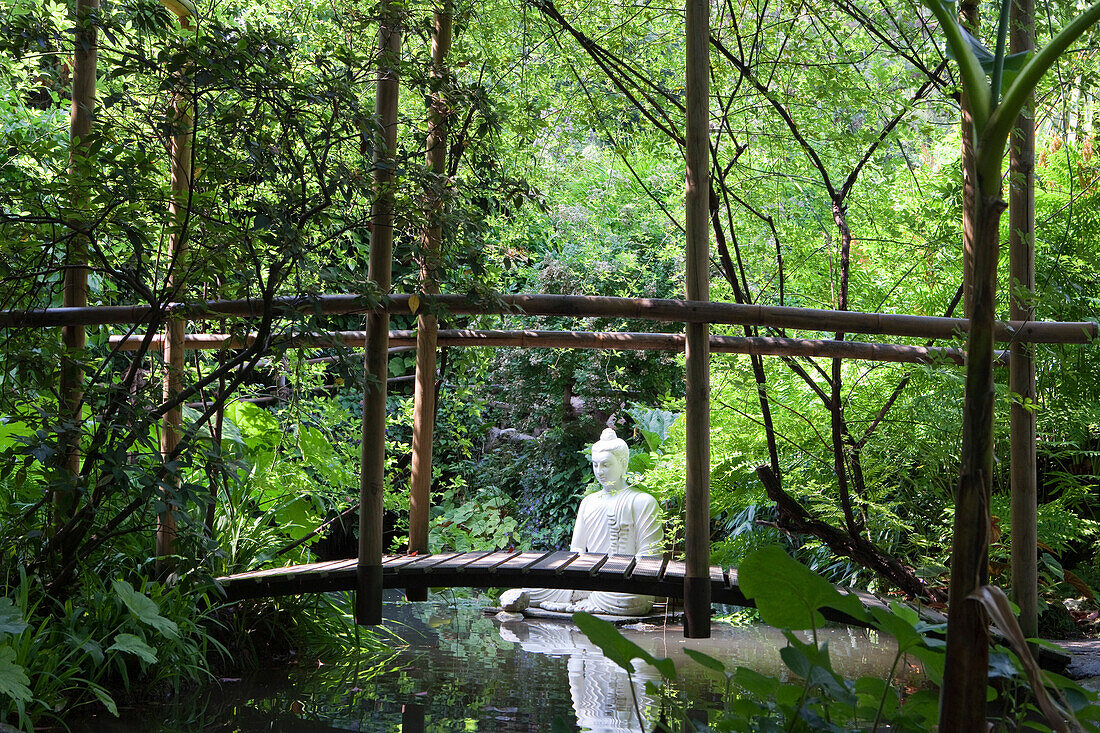 Brücke über einen Teich mit einer Buddha Statue im Garten von Andre Heller, Giardino Botanico, Gardone Riviera, Gardasee, Lombardei, Italien, Europa
