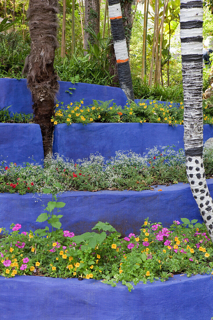 Painted tree trunks and terrace beds at Andre Hellers' Garden, Giardino Botanico, Gardone Riviera, Lake Garda, Lombardy, Italy, Europe