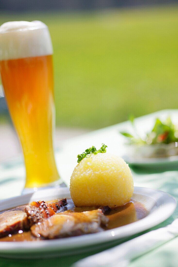 Roast pork and wheat beer, weiss beer in a beer garden near Kochel, Upper Bavaria, Bavaria, Germany