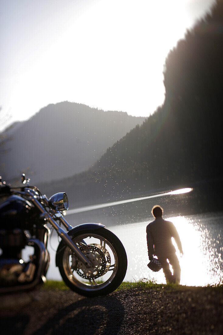 Motorbike tours around Garmisch, Person having a rest at Sylvenstein Reservoir, Upper Bavaria, Bavaria, Germany