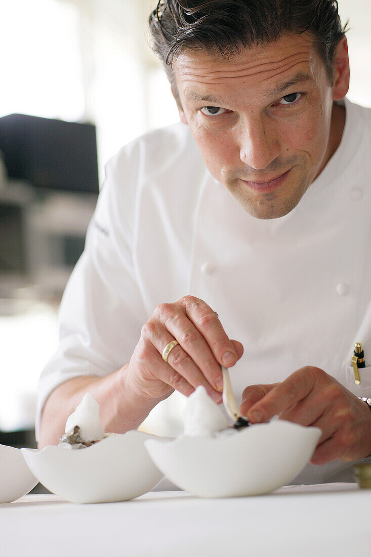 A cook arranging a dish