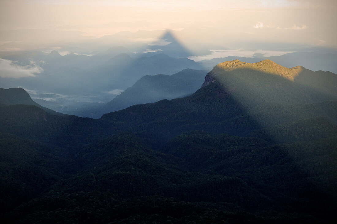 Pyramiden förmiger Schatten während Sonnenaufgang am Pilgerziel Adam's Peak Sri Pada, Blick auf das umliegende Bergland, Schatten von Bergspitze, Hochland, Sri Lanka