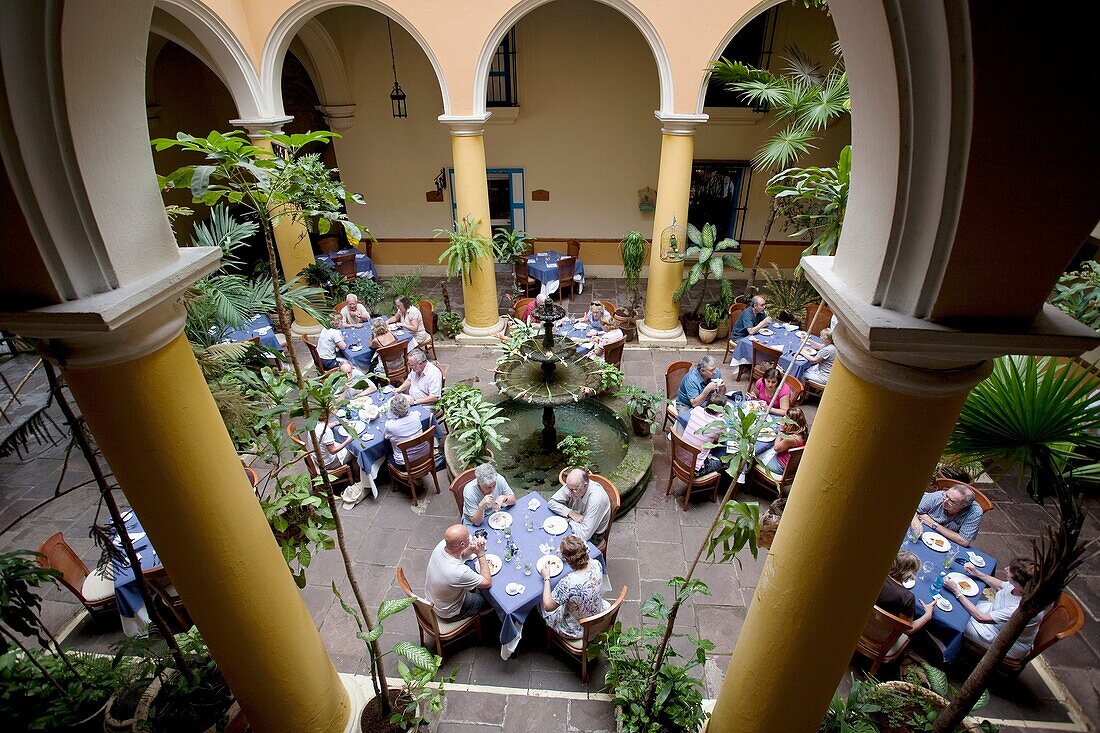 Photograph from above of the interiors of the open air restaurant El Patio with people eating and drinking, SAN IGNACIO 54, PLAZA DE LA CATEDRAL, HABANA VIEJA, HAVANA, CUBA