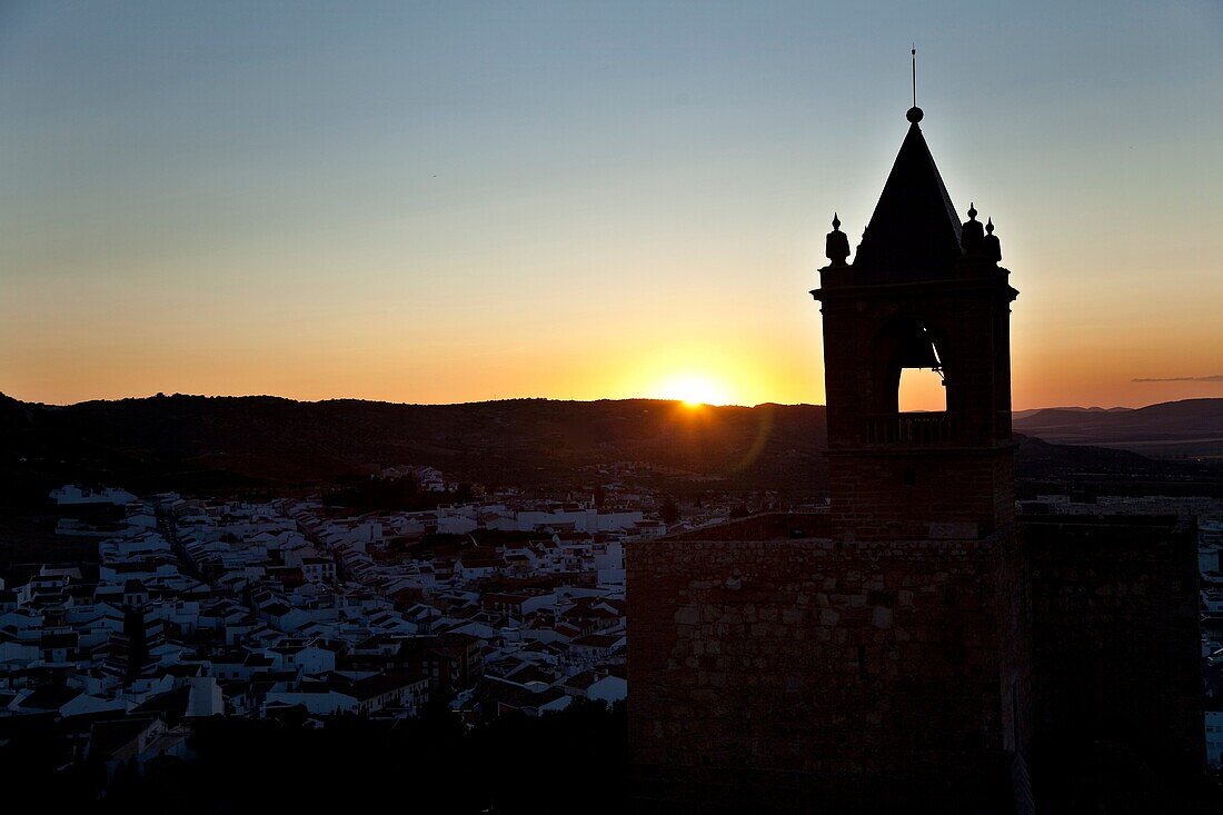 The sunset, with the Tower of Homage of the Alcazaba to the light, made from the White Tower of the Citadel of Antequera, Antequera, Andalusia, Spain
