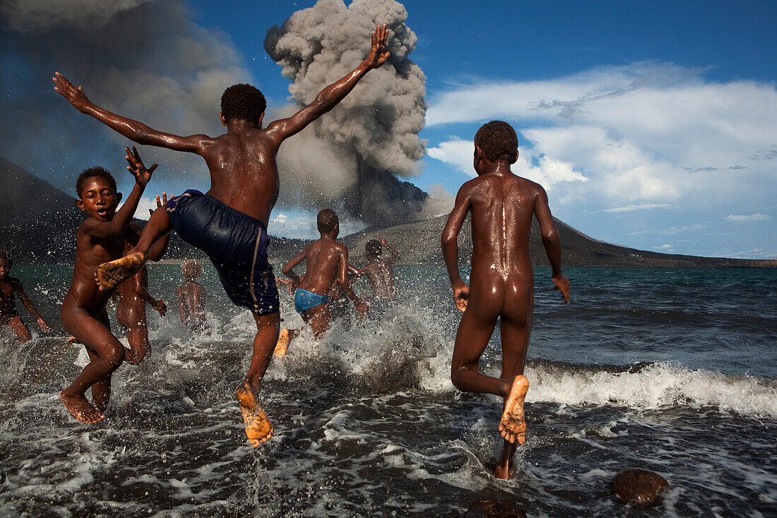 Happy children playing in the sea, Tavurvur Volcano, Rabaul, East New Britain, Papua New Guinea, Melanesia- Pacific