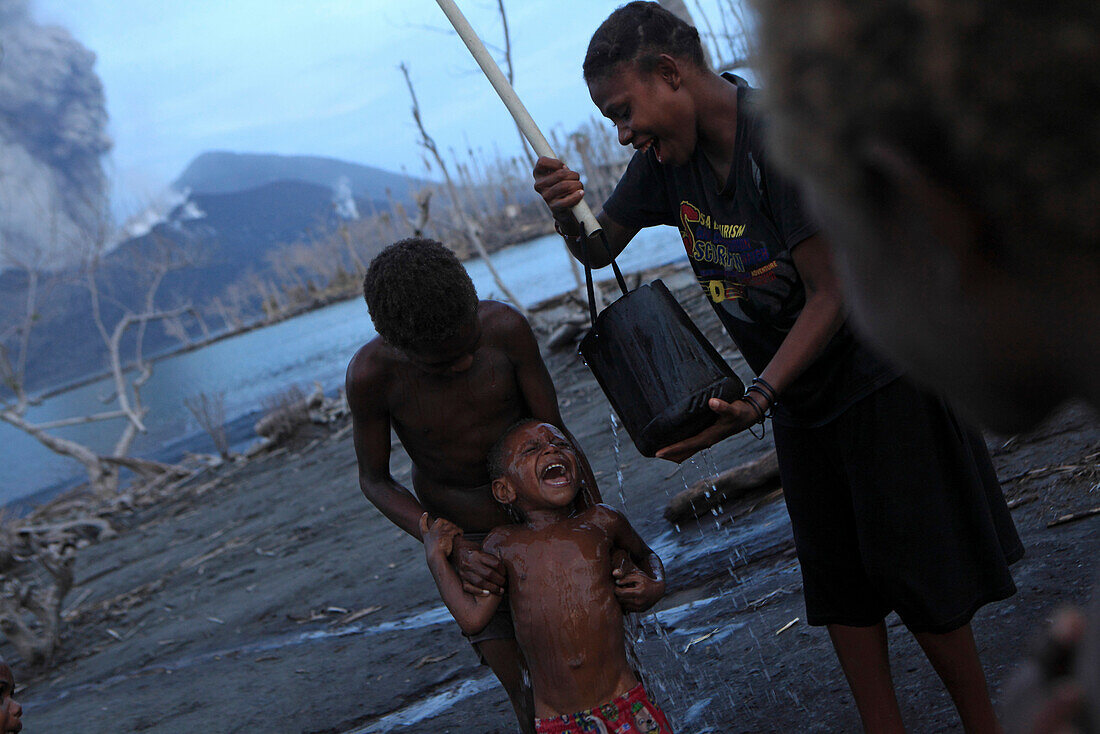 Kinder auf der Insel Matupit können sich nur mit verseuchtem Wasser waschen, Tavurvur Vulkan, Rabaul, Ost-Neubritannien, Papua Neuguinea, Pazifik