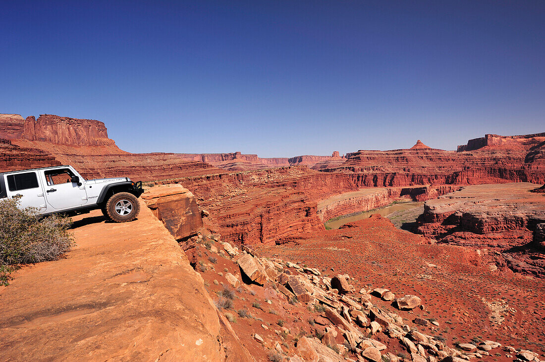Jeep steht an Felskante über Colorado River, White Rim Drive, White Rim Trail, Island in the Sky, Canyonlands Nationalpark, Moab, Utah, Südwesten, USA, Amerika