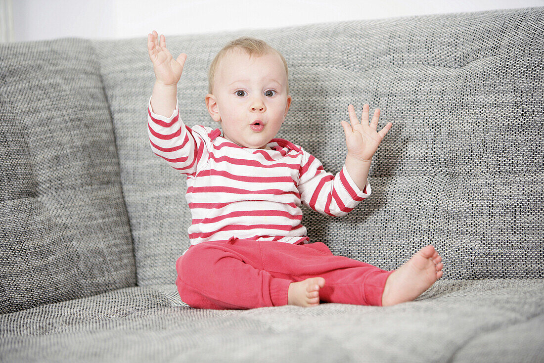 Baby sitzt auf einem Sofa, Wien, Österreich