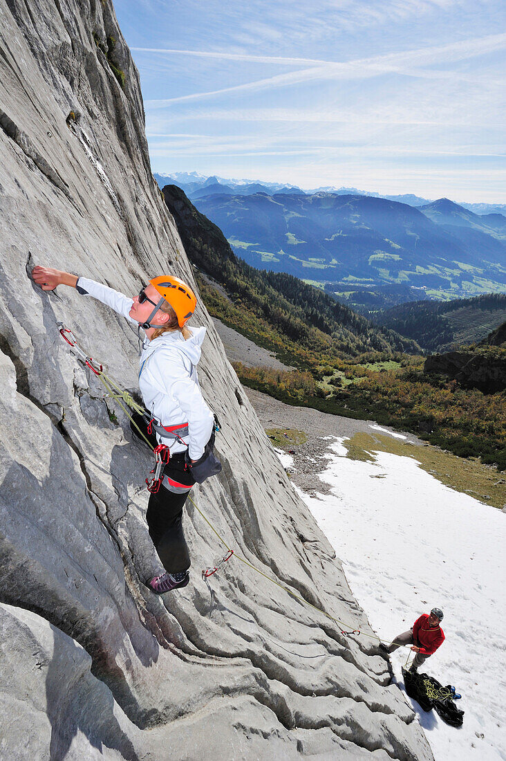 Junge Frau klettert und wird von jungem Mann gesichert, Multerkarwand, Treffauer, Wegscheidalm, Wilder Kaiser, Kaisergebirge, Tirol, Österreich