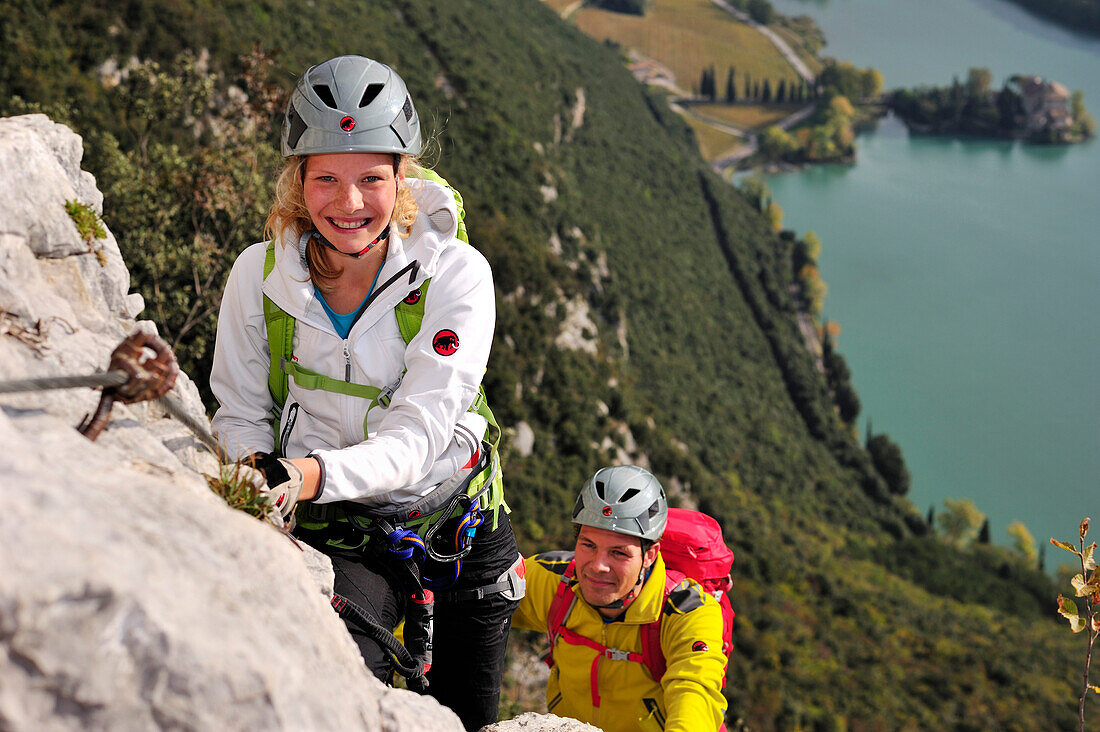 Junge Frau und junger Mann klettern am Klettersteig Rino Pisetta, Lago die Toblino, Sarche, Calavino, Trentino, Trentino-Südtirol, Italien
