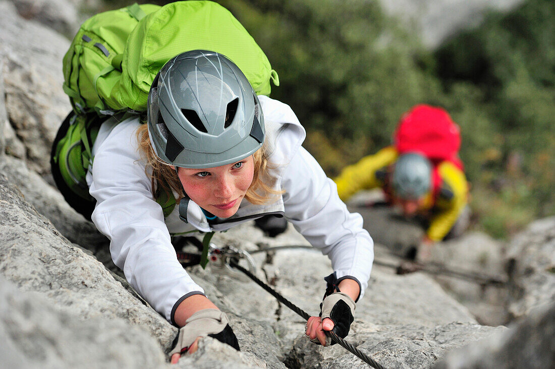 Junge Frau und junger Mann klettern am Klettersteig Rino Pisetta, Lago die Toblino, Sarche, Calavino, Trentino, Trentino-Südtirol, Italien