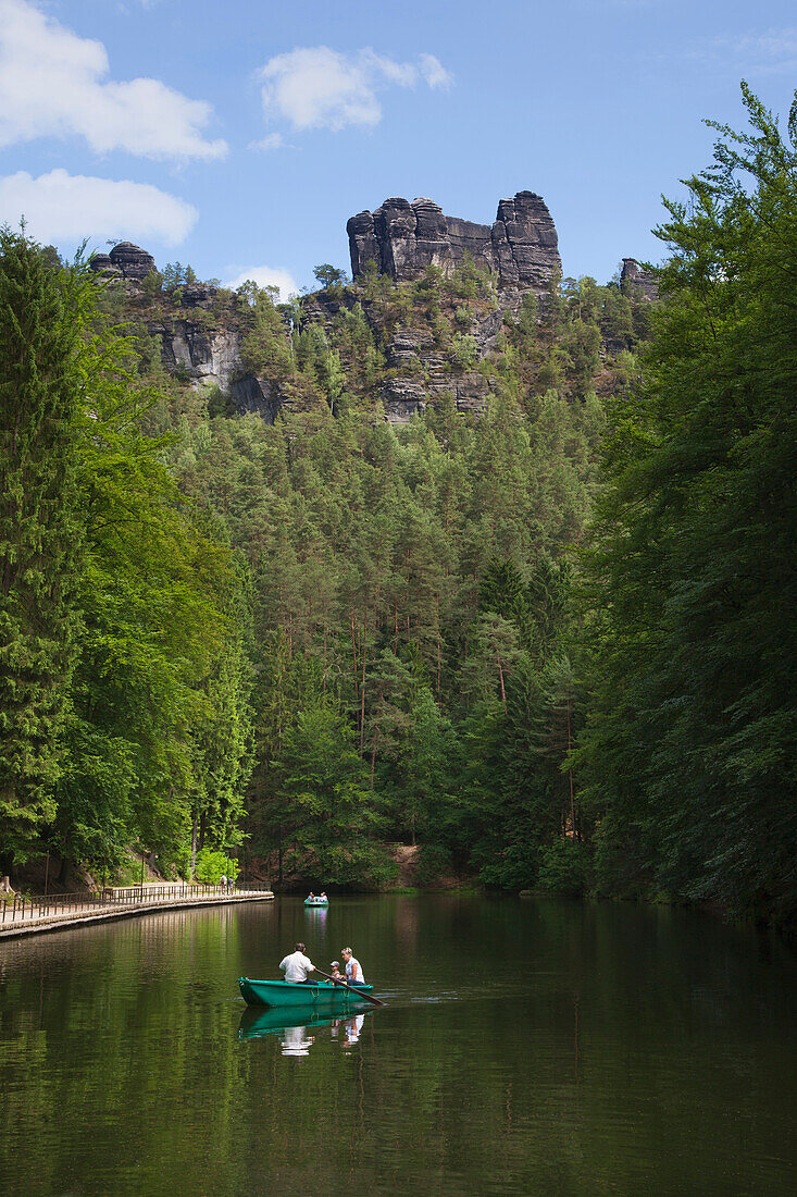 Familie im Ruderboot auf dem Amselsee im Amselgrund, Blick zur Felsformation Lokomotive, Nationalpark Sächsische Schweiz, Elbsandsteingebirge, Sachsen, Deutschland, Europa