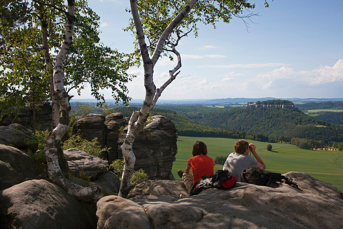 Hikers at the Pfaffenstein Rock with view onto Koenigstein castle, National Park Saxon Switzerland, Elbe Sandstone Mountains, Saxony, Germany, Europe