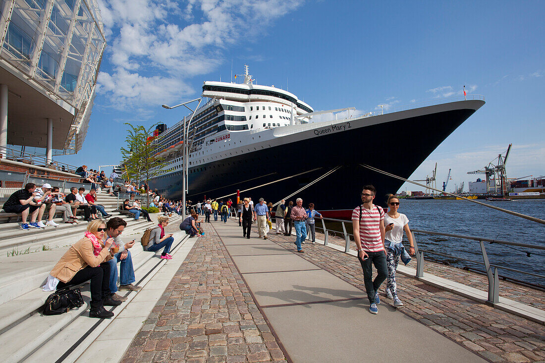 Menschen vor dem Kreuzfahrtschiff Queen Mary 2 am Anleger im Hafen, Hamburg Cruise Center Hafen City, Hamburg, Deutschland, Europa