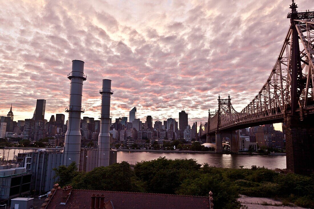 New York - United States, view on Manhattan skyline, East river and the Queensboro bridge, Queens during sunset, stormy sky