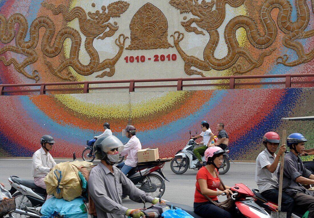 Asia, Southeast Asia, Vietnam, Hanoi, Motorbikes passing by, Wall with the date of the Millennium anniversary of the city of Hanoi