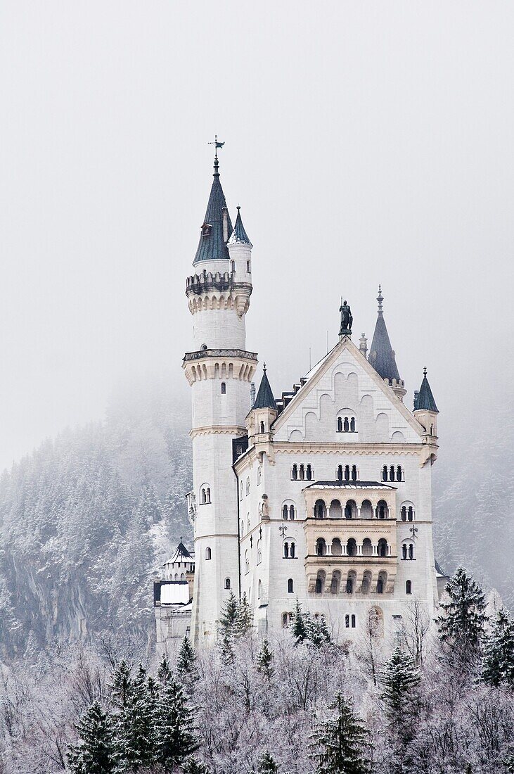 Snow covered mountains surround the famous Neuschwanstein castle, Schwangau, Bavaria, Germany